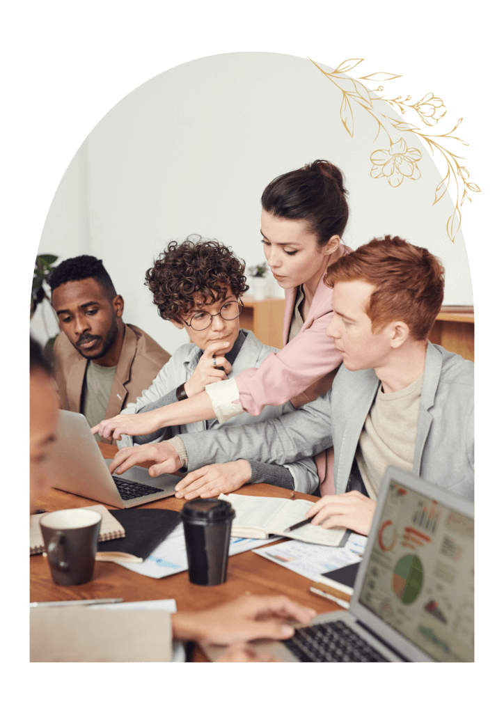 Groupe de 4 collègues en réunion devant des graphiques et un ordinateur portable